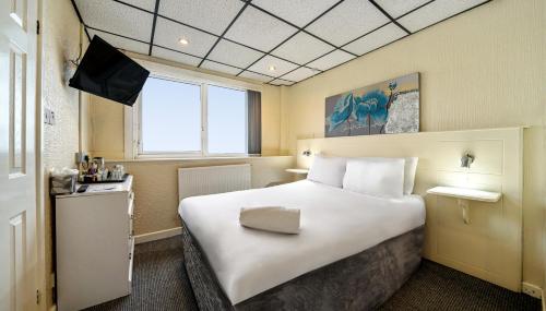a hotel room with a large bed and a television at Bluewaters Hotel Blackpool in Blackpool