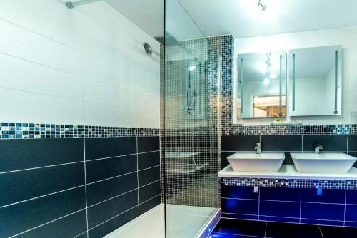 a bathroom with two sinks and a glass shower at Derby Manor in Bournemouth