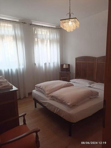 a bedroom with two beds and a chandelier at Nonna Tina apartment in Venas