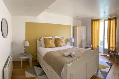- une chambre avec un grand lit aux murs jaunes dans l'établissement Ravissante maison au cœur de Cabourg, à Cabourg