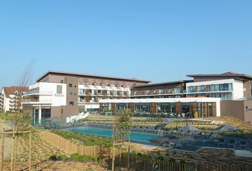 un grand bâtiment avec une piscine devant dans l'établissement Ravissante maison au cœur de Cabourg, à Cabourg