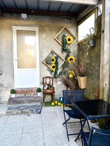 a patio with a table and sunflowers on a wall at Le Nid Marignais - Duplex au cœur du centre-ville in Marigny