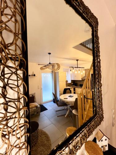 a mirror in a living room with a dining room at Le Nid Marignais - Duplex au cœur du centre-ville in Marigny