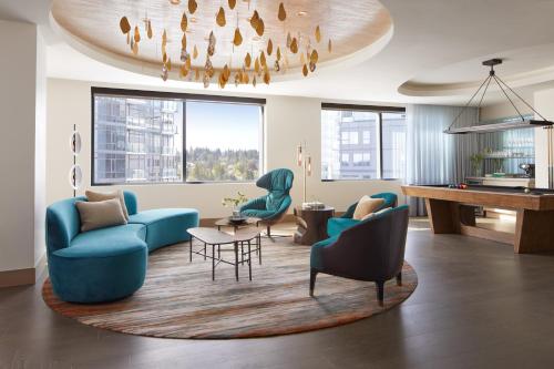 a living room with blue chairs and a piano at InterContinental Seattle Bellevue, by IHG in Bellevue
