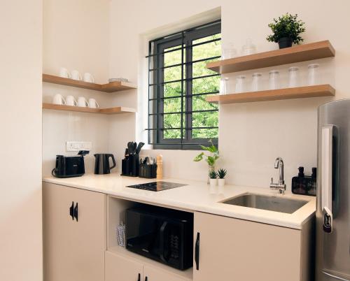 a kitchen with a sink and a microwave at The Madras Grand in Chennai
