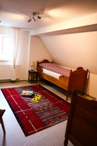 a bedroom with a bed and a rug on the floor at Landhaus - schöne Loh in Weihenzell