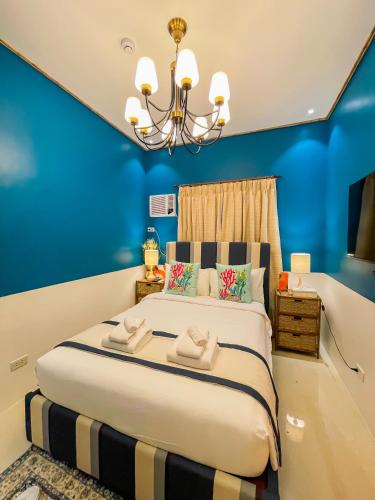 a bedroom with a large bed with blue walls at UNWND Boutique Hotel Calatagan in Batangas City