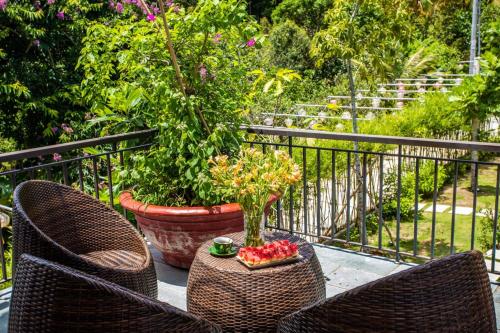 two chairs and a table with a bowl of fruit on a balcony at Casare Phu Quoc - Formerly Caesar Hotel in Phu Quoc