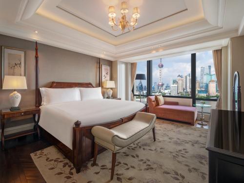 a bedroom with a large bed and a large window at Waldorf Astoria Shanghai on the Bund in Shanghai