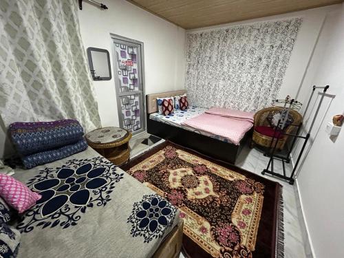 a room with two beds and rugs on the floor at Holidays homestay in Mirik