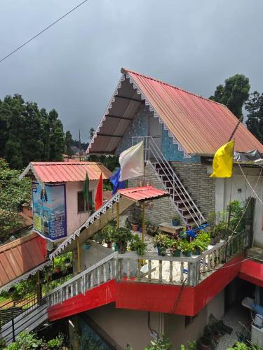 a building with a balcony with flags on it at Holidays homestay in Mirik