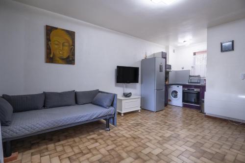 a living room with a couch and a kitchen at Joli Studio Proche De La Mer in Le Pradet