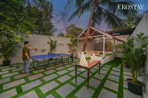 a man standing in a yard with two ping pong tables at EKOSTAY Gold - Driftwood Villa in Alibaug