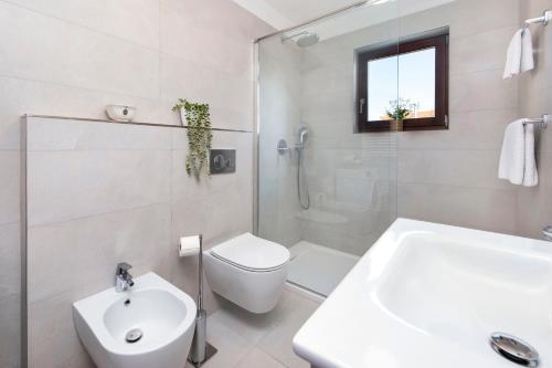 ein weißes Badezimmer mit Toilette und Waschbecken in der Unterkunft Apartments Carmelo in Rovinj