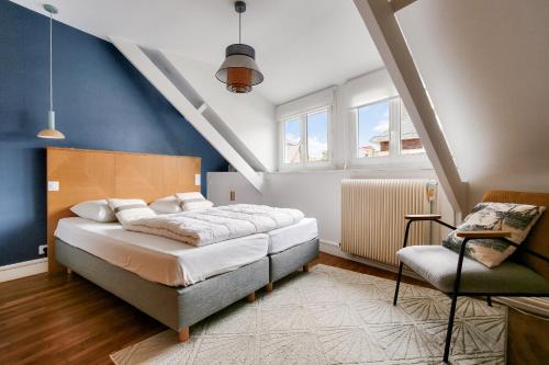 a bedroom with a bed and a chair at À 200m de la plage, maison cosy pour 4 in Dinard