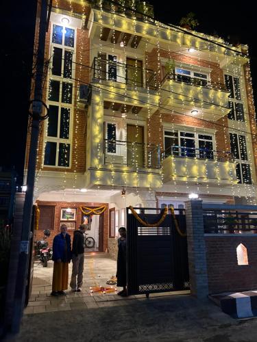 a group of people standing outside of a building at night at Raniban Suites - Apartment Home in Kathmandu
