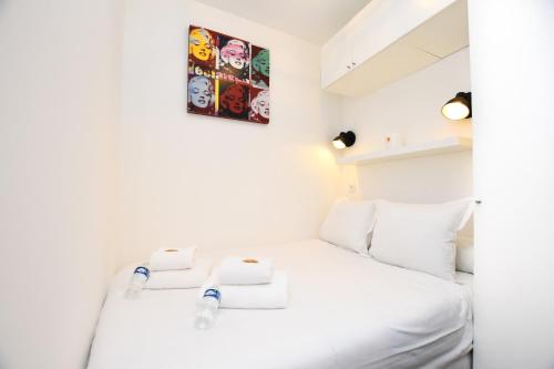 - une chambre avec un lit blanc et 2 serviettes dans l'établissement Charming apartment - 1BR-2P - Petit-Montrouge, à Paris