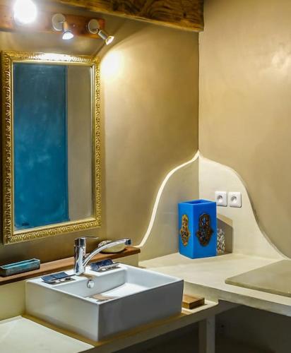 une salle de bain avec un lavabo blanc et un miroir dans l'établissement Maison de vacances pleine nature, à Mourèze