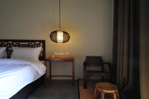 a bedroom with a bed and a table and a lamp at Villa Bangkok in Bangkok