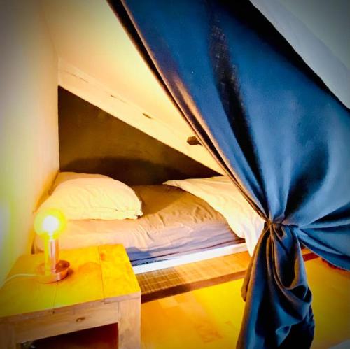 Ce lit se trouve dans un dortoir doté d'une lampe sur une table. dans l'établissement Loft de charme Louvre Tuileries Palais Royal, à Paris