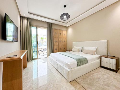 una camera da letto con un letto, una scrivania e una televisione di Cosy Elegant Piscine a proximite a Tangeri