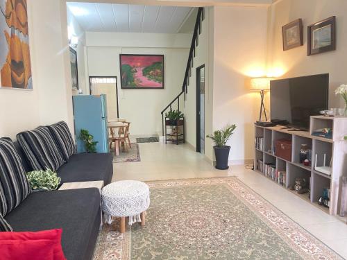 a living room with a couch and a tv at Baan Mali Three in Hua Hin