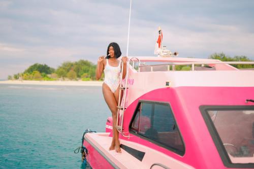 a woman on a boat talking on a cell phone at PinkCoco Gili Trawangan - Constant Surprises - for Cool Adults Only in Gili Trawangan