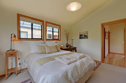 a bedroom with a large white bed with a window at Moon River in Gardners Bay