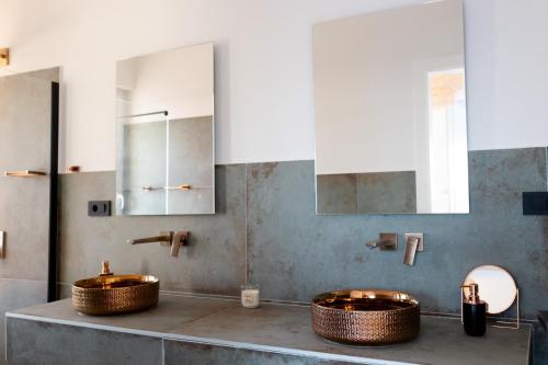 zwei Waschbecken im Bad mit zwei Spiegeln in der Unterkunft Villa Koko Vinišće with heated pool and sea view in Vinišće