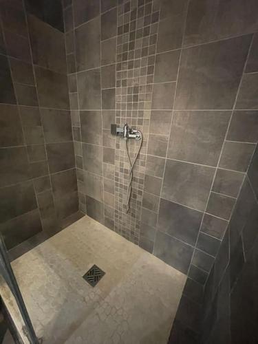 La salle de bains est pourvue d'une douche et de murs carrelés. dans l'établissement Palma Studio bis 4 pers - 100m plage, à Port-la-Nouvelle