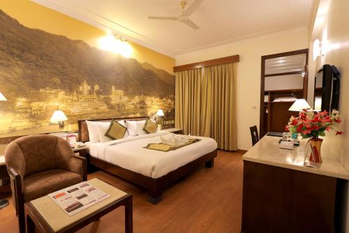 a hotel room with a bed and a chair at Regenta Orko's Haridwar, Motichur, 10 min from Har ki Pauri in Haridwār
