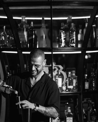 a man standing in a bar holding a drink at Courtyard by Marriott Casablanca Downtown in Casablanca