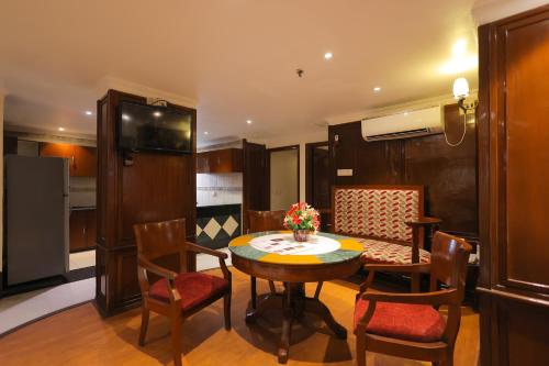 a kitchen and dining room with a table and chairs at Regenta Orko's Haridwar, Motichur, 10 min from Har ki Pauri in Haridwār