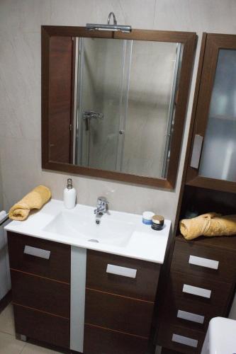 a bathroom with a sink and a mirror at Apartamento Noja Playa Trengandin in Noja