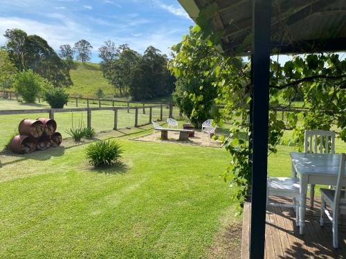 a garden with a table and chairs and a fence at Little Farmhouse Near The Dairy in Warranulla