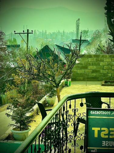 a view of a garden with a tree and a fence at Everest Guest House in Gulmarg