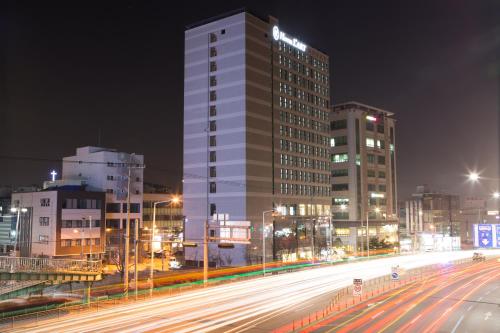 a tall building in a city at night at Hotel L'art Gimpo in Gimpo
