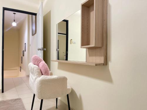 a bathroom with two pink chairs and a mirror at Baan Mali Three in Hua Hin