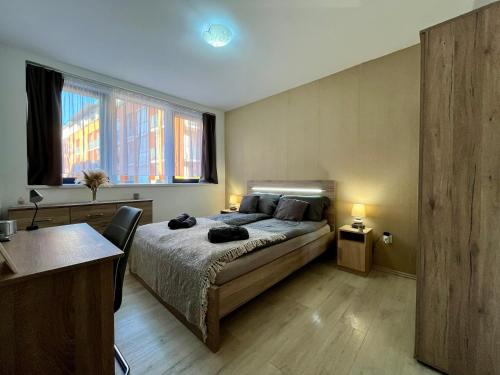 1 Schlafzimmer mit einem Bett, 2 Fenstern und einem Tisch in der Unterkunft City Centre Simonffy Apartment in Debrecen