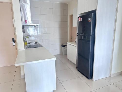 a kitchen with a black refrigerator and a sink at Ubays Zetepark House in Kuala Lumpur