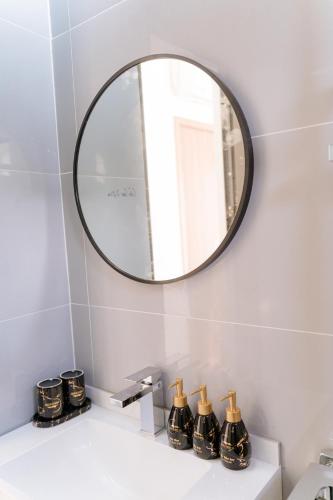 a mirror above a bathroom sink with bottles on it at Apollo Hotel in Dồng Văn
