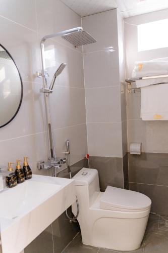 a bathroom with a toilet and a sink and a mirror at Apollo Hotel in Dồng Văn