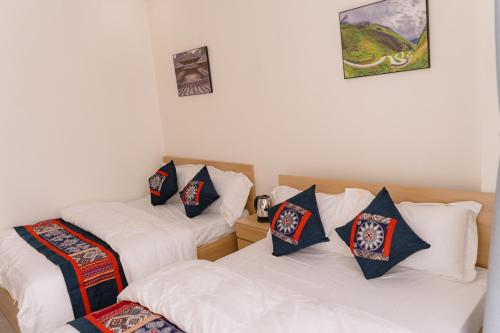 a room with two twin beds with pillows on them at Apollo Hotel in Dồng Văn