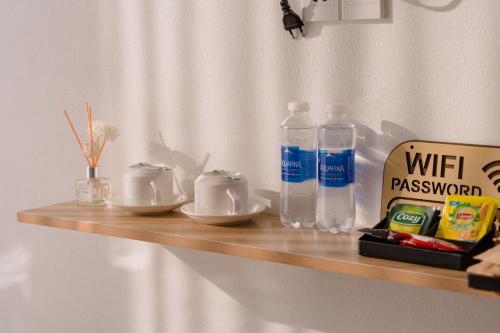 a wooden shelf with two empty dishes and bottles of water at Apollo Hotel in Dồng Văn