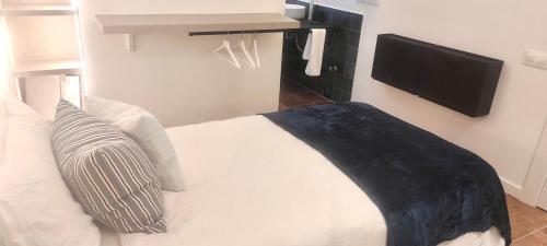a bedroom with a bed with a tv on the wall at Guest House Espinardo Murcia Casa Universitaria in Murcia