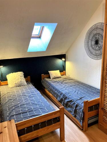 Cette chambre comprend 2 lits jumeaux et une lucarne. dans l'établissement Pléiades , Apt 5 p, 1 grande chambre, un coin montagne et une place de parking , belle vue, à Les Deux Alpes
