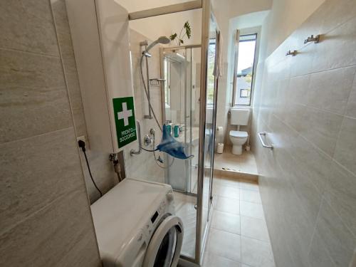 a bathroom with a shower and a washing machine at Moderno appartamento sulle Rive in Trieste