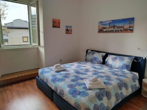 a bedroom with a bed with two towels on it at Moderno appartamento sulle Rive in Trieste