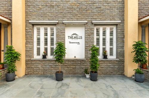 a facade of a brick building with potted plants at The Hills collective with private plunge pool My Downtown Hotel in Udaipur