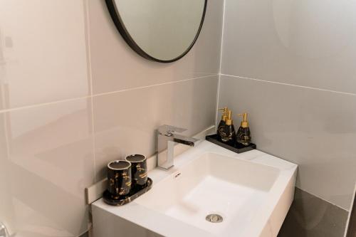 a bathroom with a white sink and a mirror at Apollo Hotel in Dồng Văn